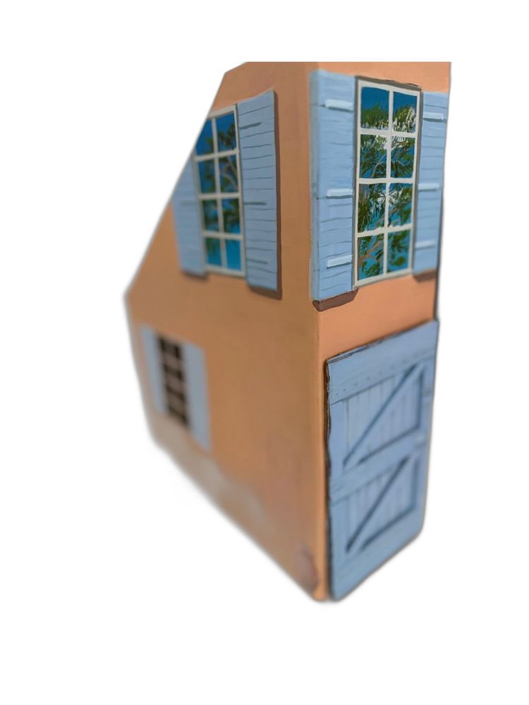 Peach wooden house object with blue shutters